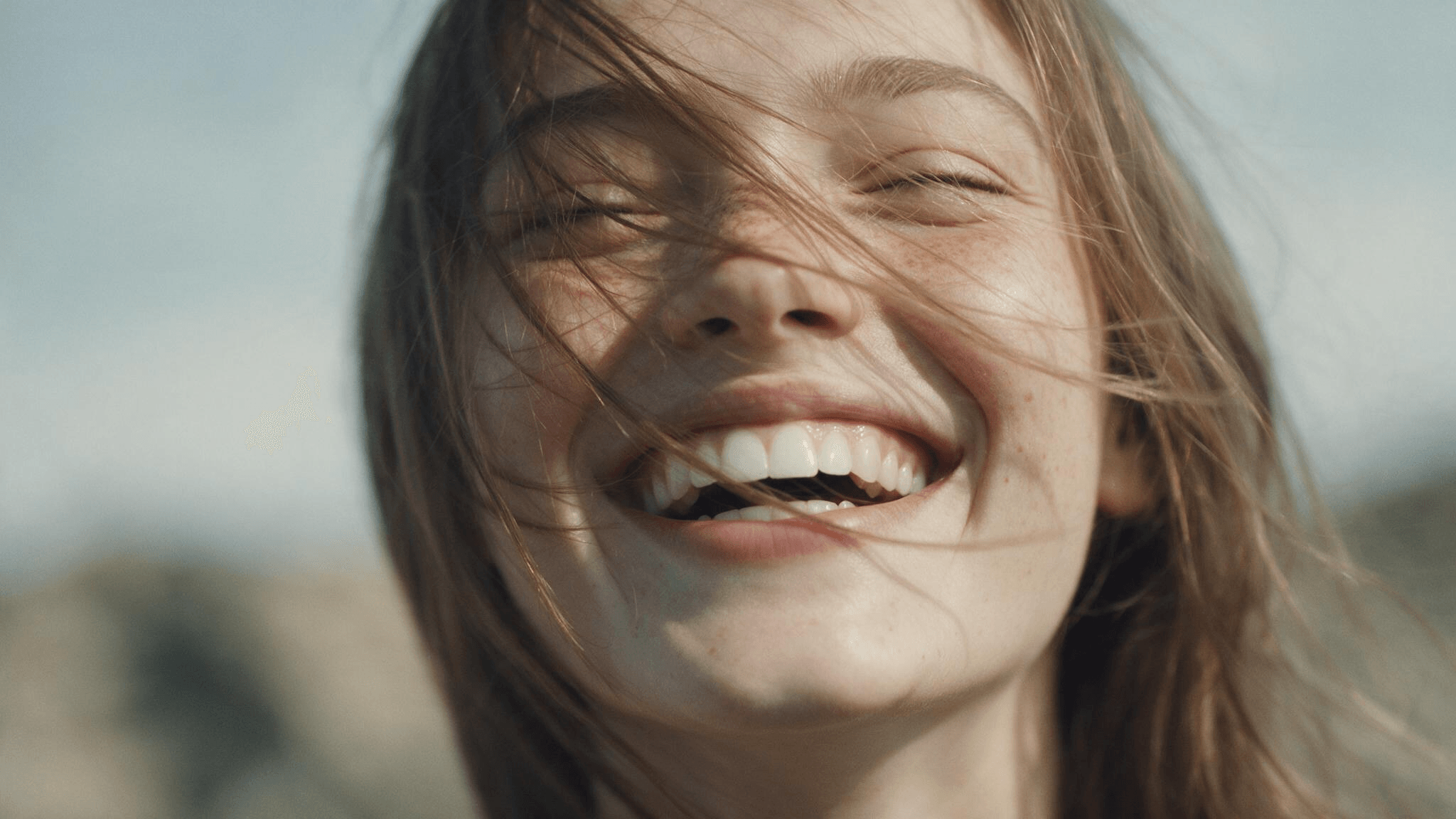A headshot of a lively happy young woman with a smile.